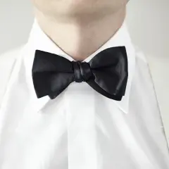 Biała koszula z czarną muszką i białymi szelkami. Idealny zestaw, gdy zastanawiasz się, jaka koszula do muszki.