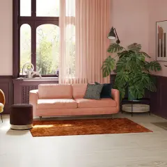 Salon z pudrowym różem, kanapą, fotelami w kolorze musztardowym i brązowym dywanem. Idealnie, co pasuje do pudrowego różu.