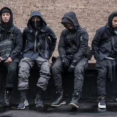 Czterech mężczyzn w czarnych, funkcjonalnych ubraniach, pokazujących, techwear co to.