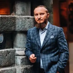 Elegancki mężczyzna w garniturze w kratę. Zastanawiasz się, jaki krawat do garnituru w kratę będzie najlepszy? Ten styl to klasa sama w sobie.