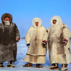 Trzech mężczyzn w tradycyjnych, futrzanych anorakach, chroniących przed mrozem. To właśnie anorak co to za odzież!
