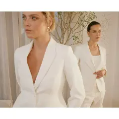 Dwie kobiety w białych garniturach, uosobienie power dressing. Eleganckie, pewne siebie, gotowe na podbój świata.