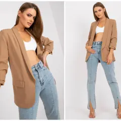 Elegancka marynarka i jeansy tworzą stylową stylizację. Modelka prezentuje modne marynarka i jeansy.