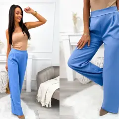 Eleganckie błękitne spodnie palazzo, idealne do letnich stylizacji. Modelka prezentuje je z beżowym topem.