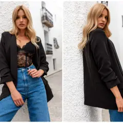 Blondynka w czarnej marynarce damskiej i koronkowej bieliźnie, z dżinsami. Inspiracja, jak nosić marynarkę damską.