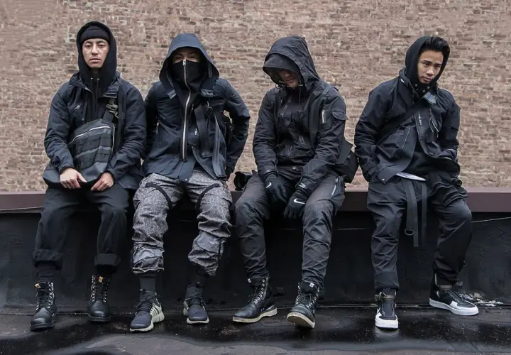 Czterech mężczyzn w czarnych, funkcjonalnych ubraniach, pokazujących, techwear co to.
