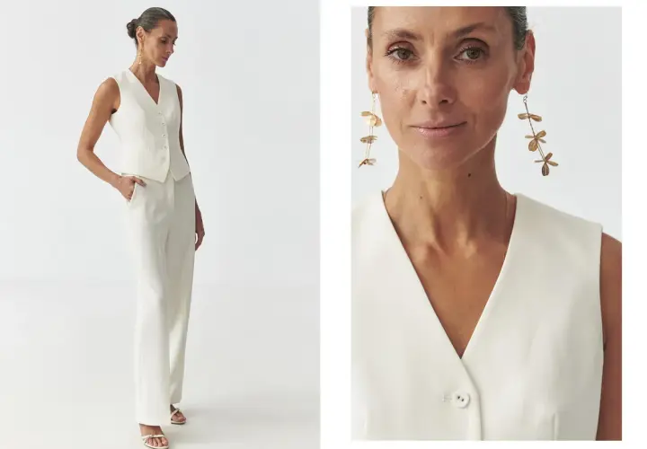 Elegancka stylizacja semi casual: biały garnitur z kamizelką i szerokimi spodniami, uzupełniony o długie, złote kolczyki.