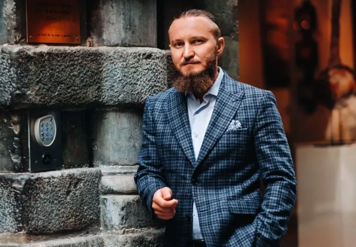 Elegancki mężczyzna w garniturze w kratę. Zastanawiasz się, jaki krawat do garnituru w kratę będzie najlepszy? Ten styl to klasa sama w sobie.