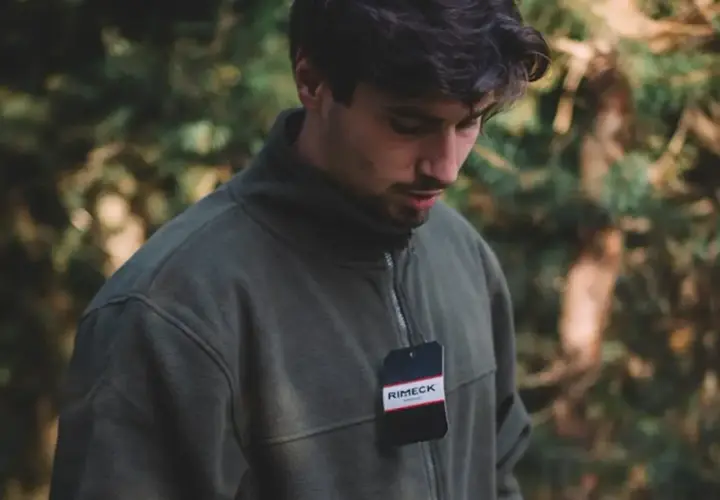 Mężczyzna w zielonej bluzie z metką. Idealna bluza do szarych dresów na jesienny spacer.