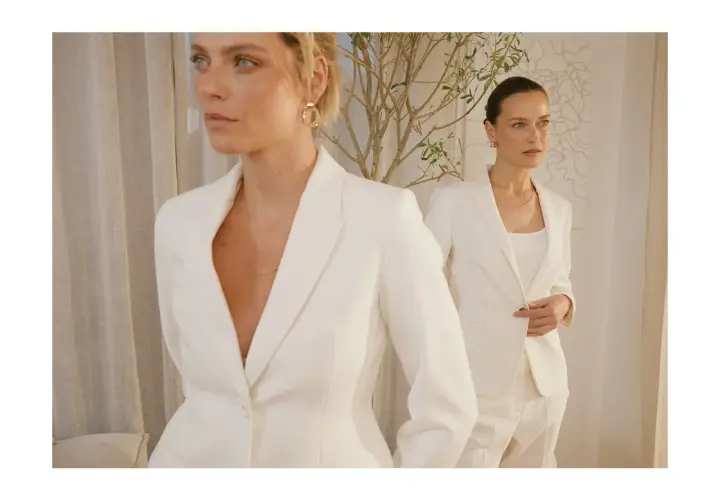 Dwie kobiety w białych garniturach, uosobienie power dressing. Eleganckie, pewne siebie, gotowe na podbój świata.