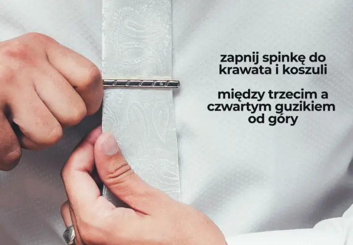 Mężczyzna zapina spinkę do krawata i koszuli między trzecim a czwartym guzikiem od góry. Elegancki sposób na noszenie spinki do krawata.