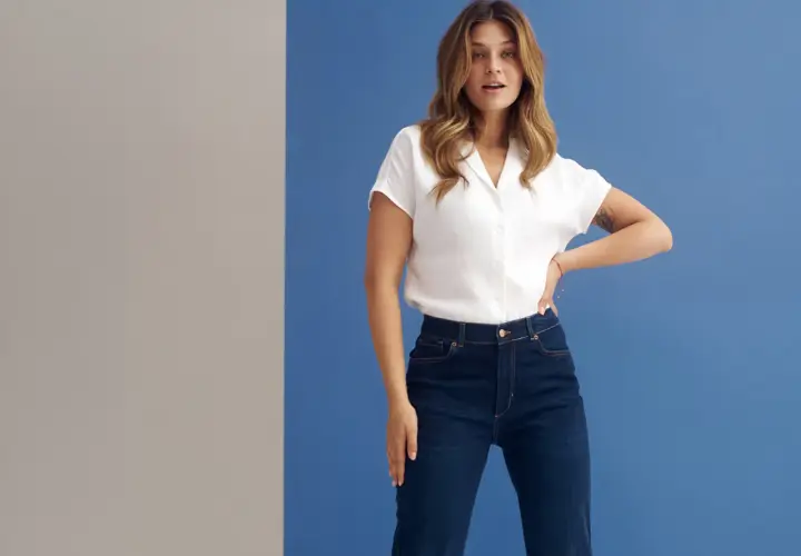 Kobieta w białej koszuli i granatowych jeansach wide leg. Idealne dla każdej kobiety ceniącej wygodę i styl.