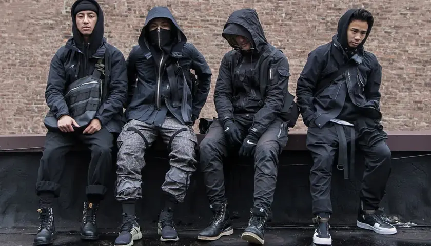 Czterech mężczyzn w czarnych, funkcjonalnych ubraniach, pokazujących, techwear co to.