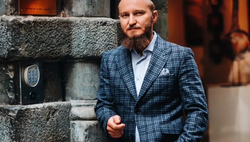 Elegancki mężczyzna w garniturze w kratę. Zastanawiasz się, jaki krawat do garnituru w kratę będzie najlepszy? Ten styl to klasa sama w sobie.