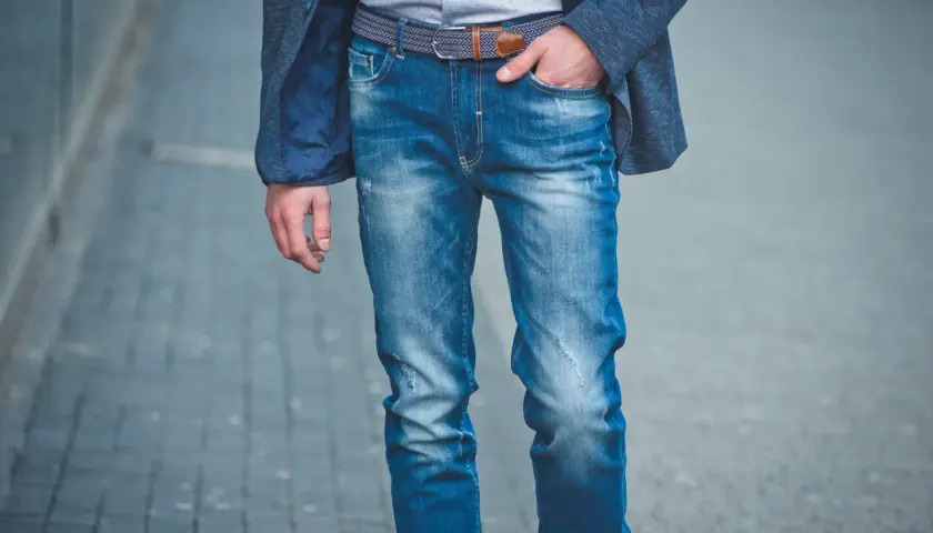 Męskie jeansy z przetarciami i modnym paskiem, idealne na co dzień. Różne rodzaje jeansów męskich dostępne w sklepach.