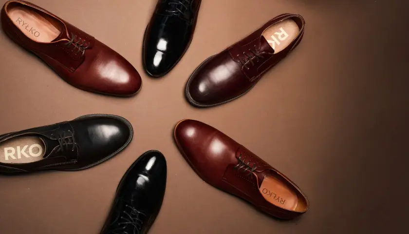 Eleganckie buty męskie: czarne lakierki i brązowe półbuty. Idealne, by dobrać odpowiednie buty do czarnego garnituru.