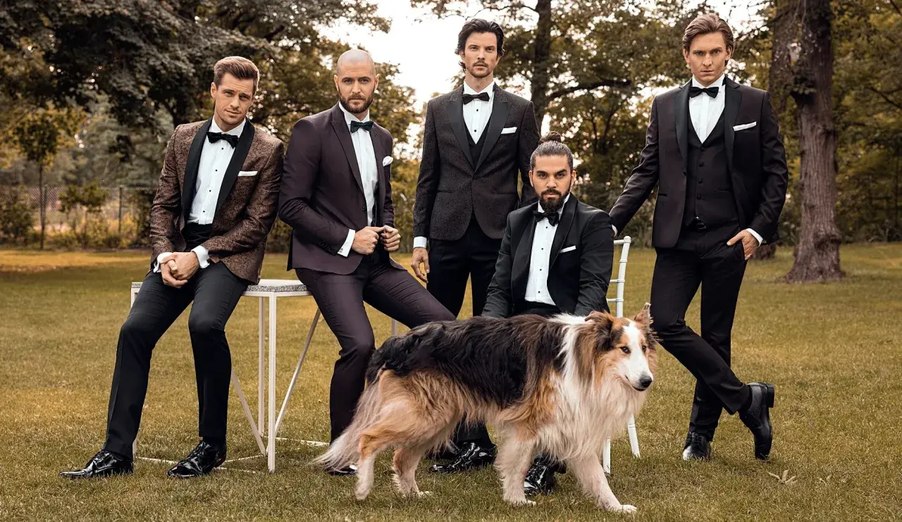 Eleganccy panowie w smokingach i błyszczących butach, a obok nich pies. Idealne połączenie stylu i klasy, pokazujące jakie buty do smokingu pasują najlepiej.