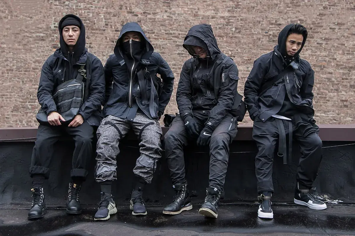 Czterech mężczyzn w czarnych, funkcjonalnych ubraniach, pokazujących, techwear co to.