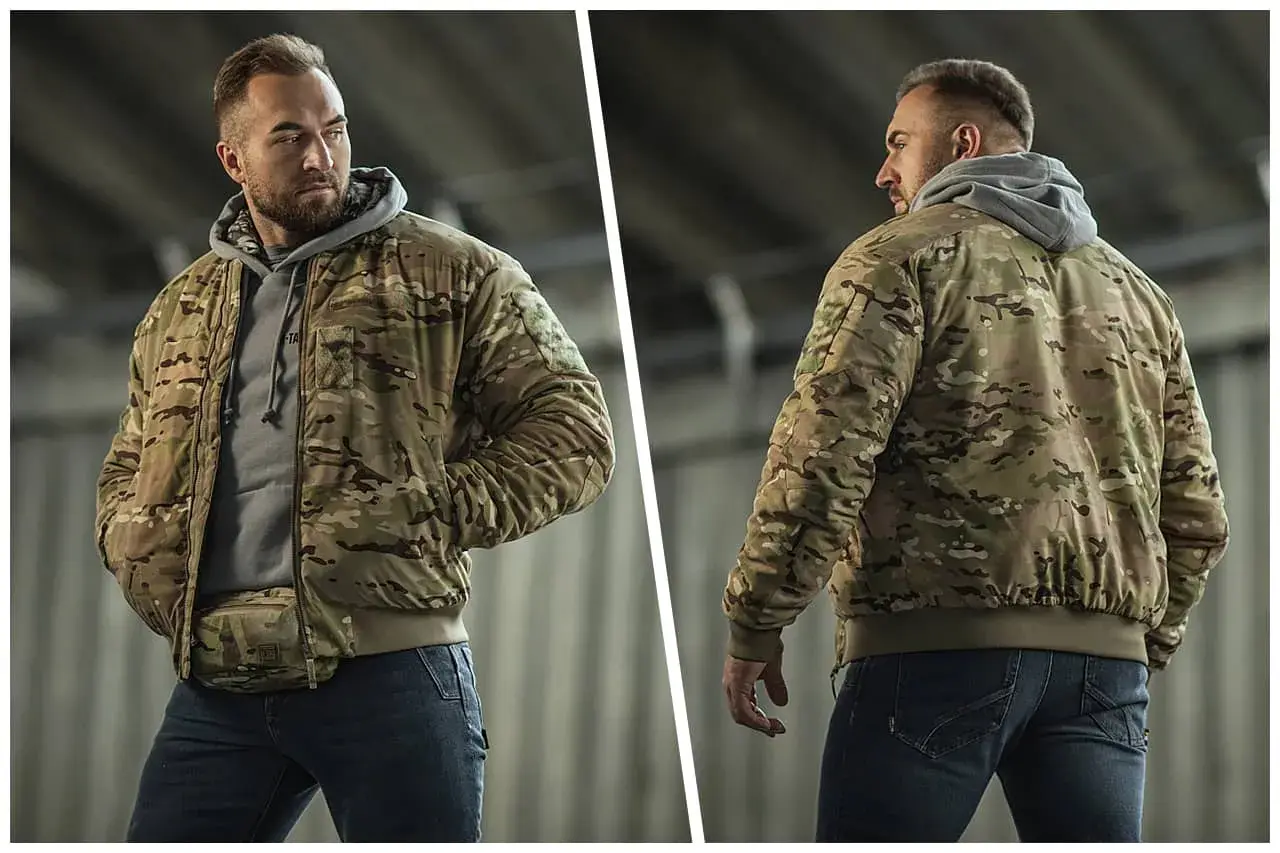 Mężczyzna w kurtce w kamuflażu, styl militarny, z torbą na biodrach.