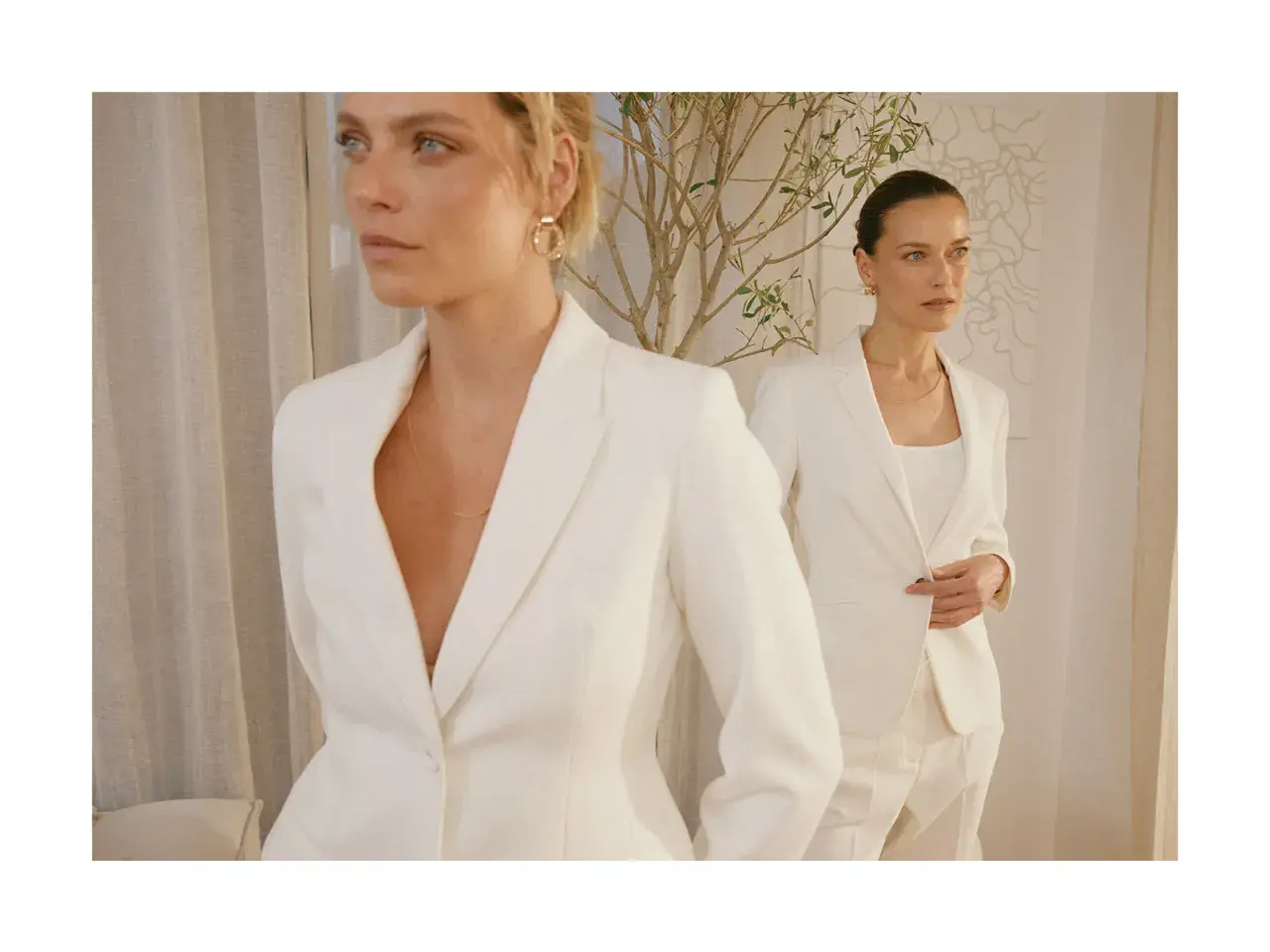 Dwie kobiety w białych garniturach, uosobienie power dressing. Eleganckie, pewne siebie, gotowe na podbój świata.