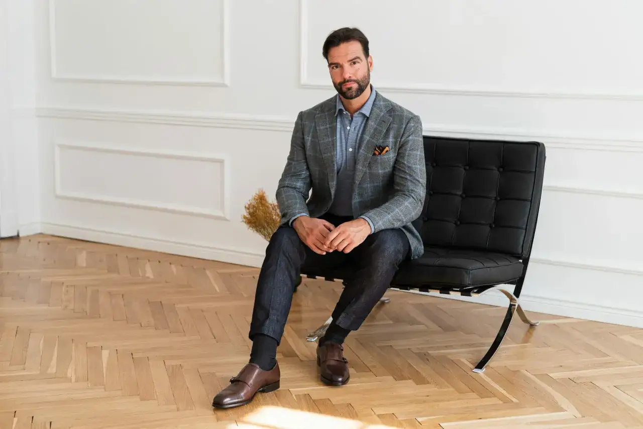 Elegancka marynarka i jeansy – męskie stylizacje na co dzień i od święta. Stylowy mężczyzna w kratowanej marynarce i ciemnych spodniach.