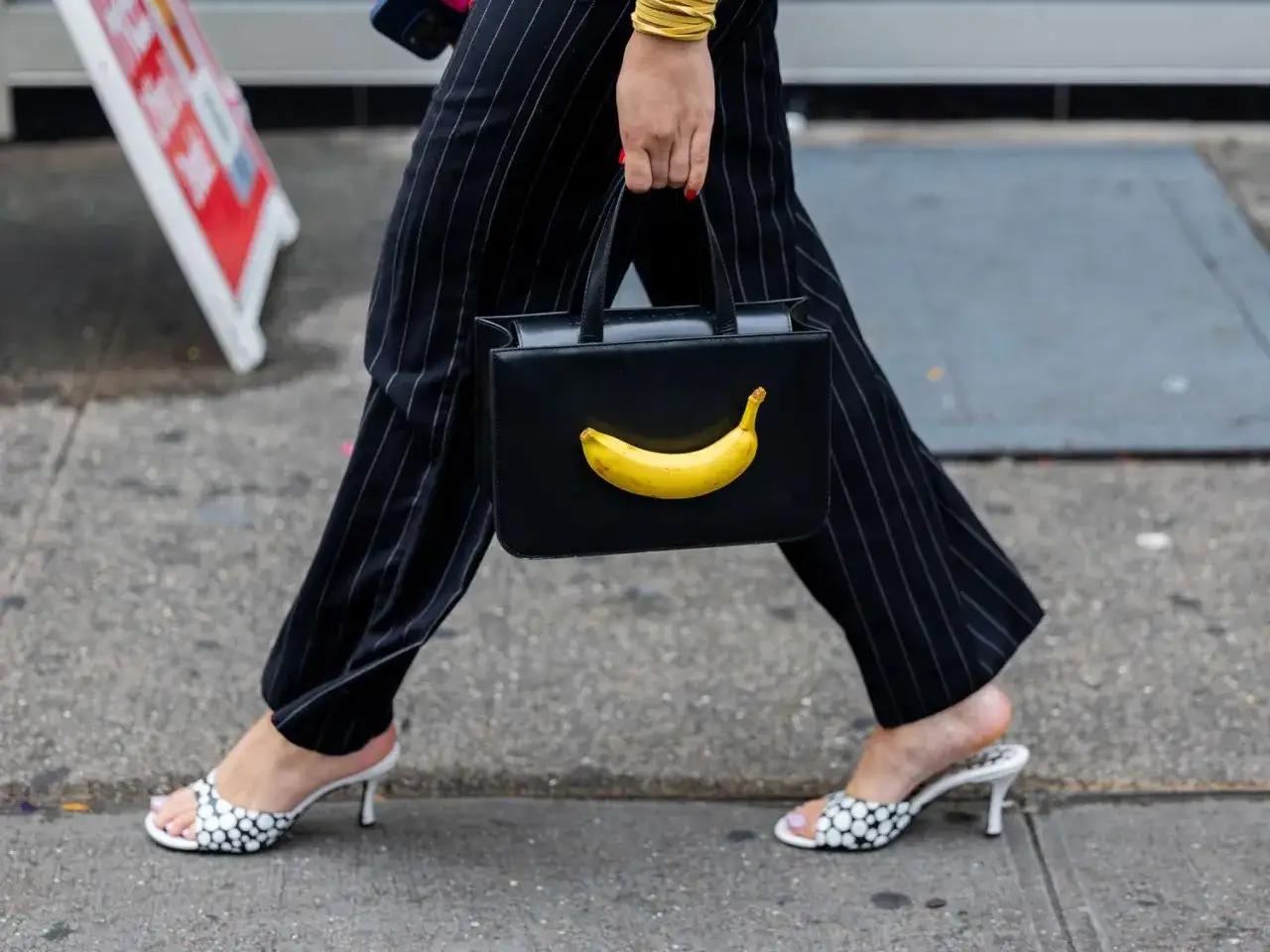 Czarna torebka z bananem i żółta torebka stylizacje. Eleganckie spodnie w paski i buty w groszki.